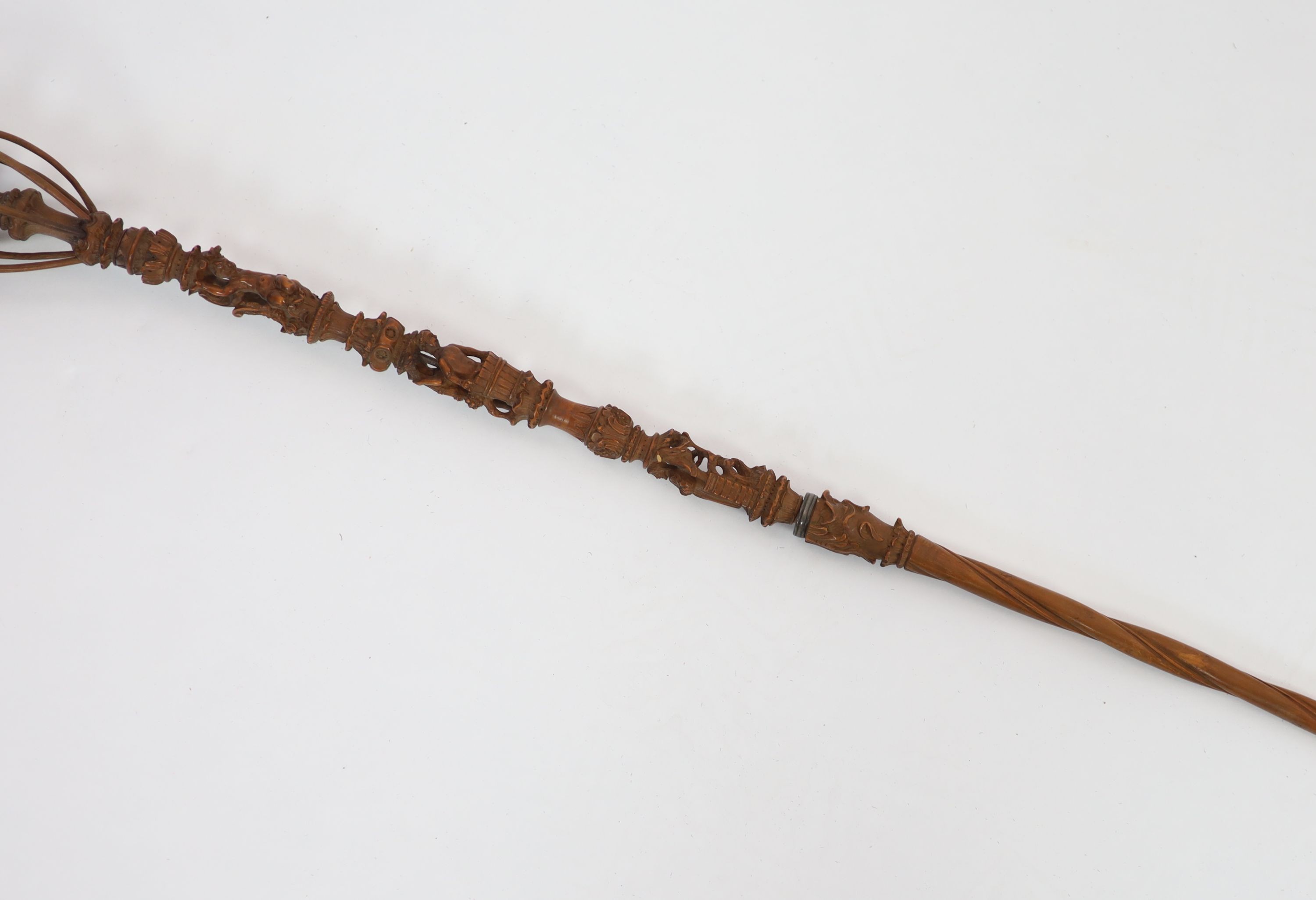 A 17th century French boxwood distaff (wool winder), carved with numerous figures and scrolls, over a spiral fluted stem, 49 & 36cm.